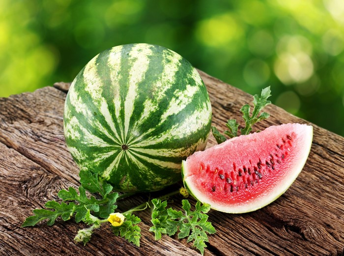 Watermelon and slice on wood