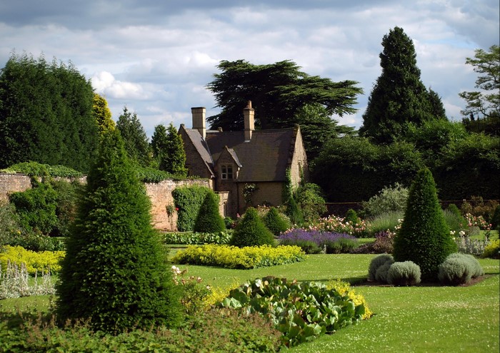 English Garden with Stone Cottage and Manicured Shrubs