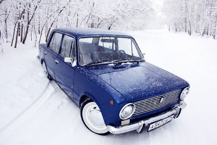 Blue VAZ-2101 car in a snowy forest