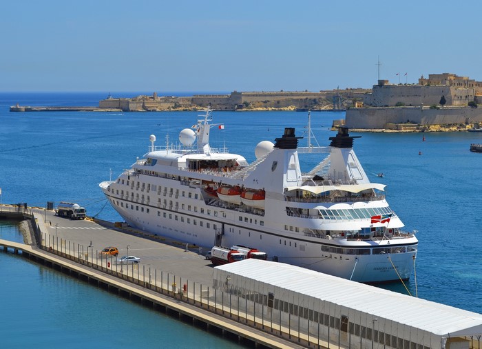 Seabourn Legend cruise liner docked in a harbor with Malta fortifications in background