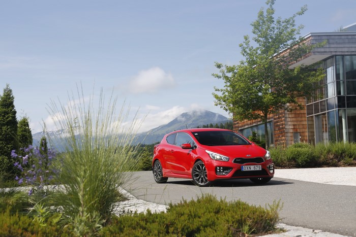 Red 2013 Kia Pro Ceed GT parked near a building
