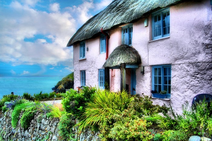 Thatched roof cottage by the sea in Cornwall, England