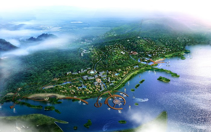 Aerial view of a coastal resort with forested hills and a lake