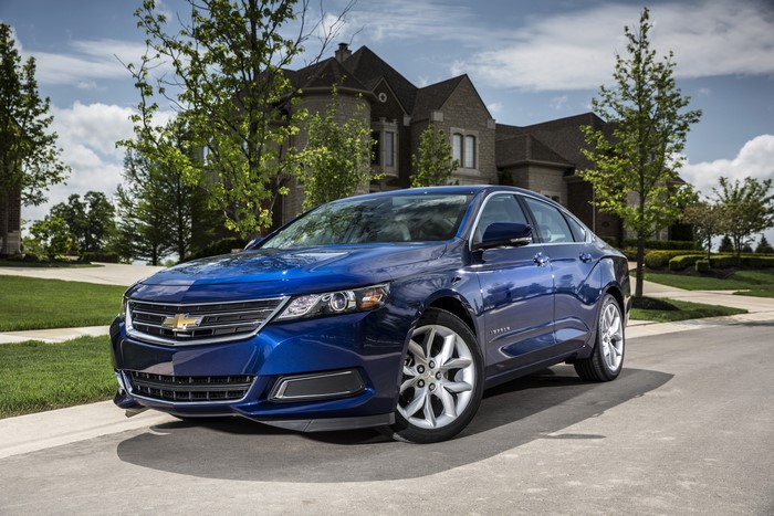 Blue Chevrolet Impala parked in front of a house