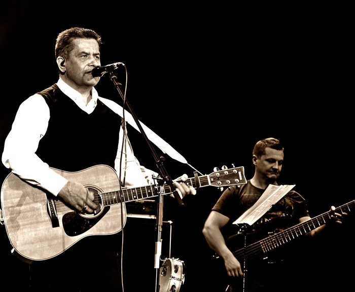 Men playing guitars on stage