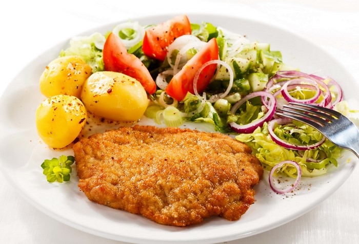 Breaded meat cutlet with potatoes and salad