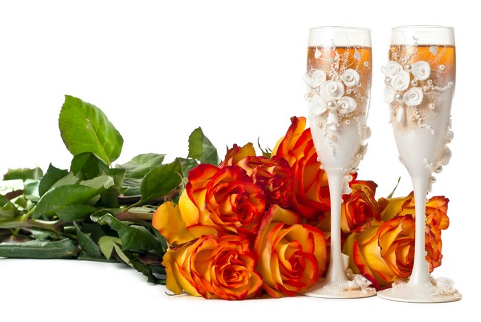 Champagne glasses and orange-red roses