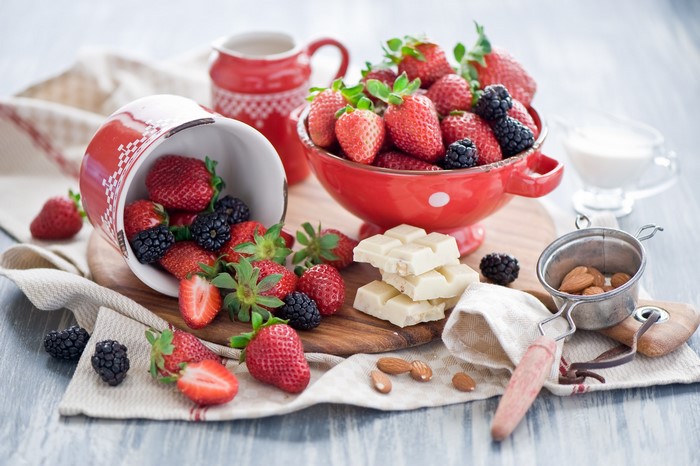 Still life with strawberries, blackberries, white chocolate, and almonds