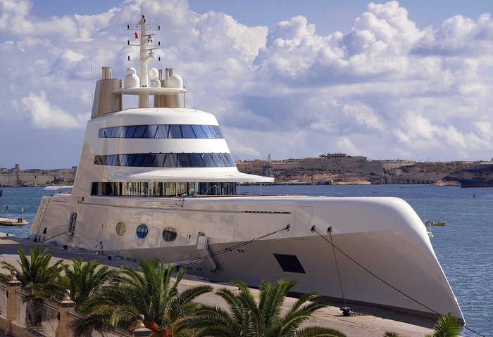 Superyacht A docked in a harbor with Malta in the background
