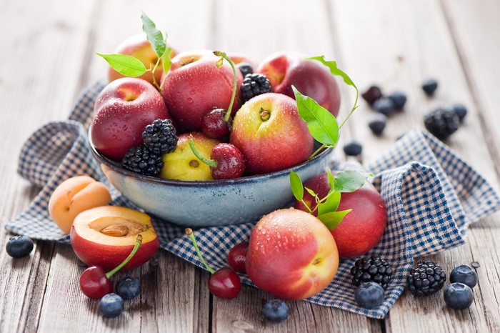 Bowl of fresh peaches, cherries, blackberries, and blueberries