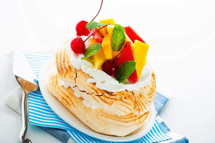 Pavlova dessert with fresh fruit and whipped cream