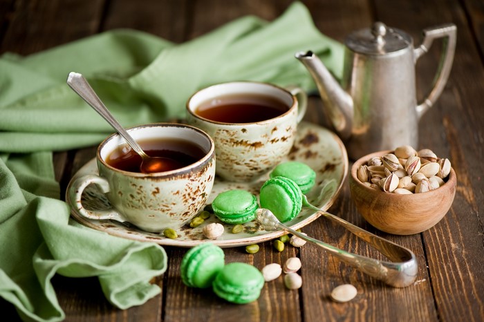 Tea cups with macarons and pistachios