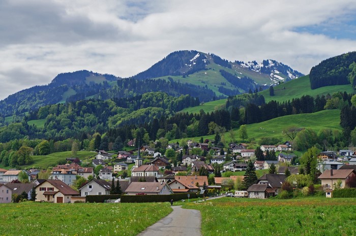 Village nestled in the Swiss Alps with snow-capped mountains