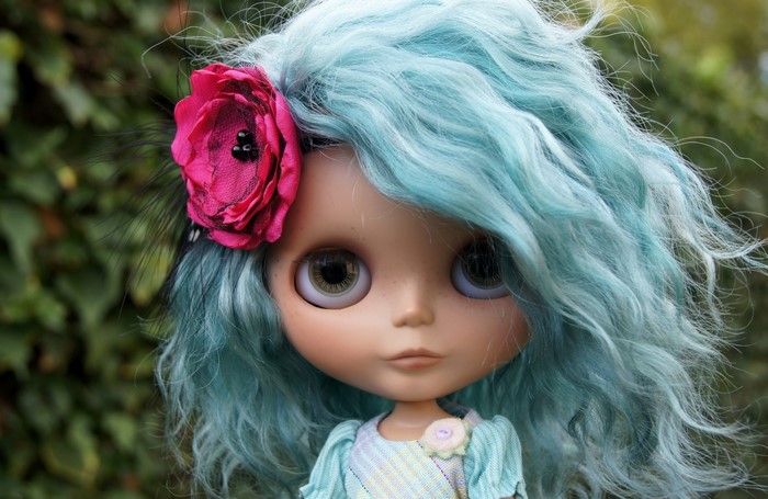 Doll with blue hair and pink flower accessory