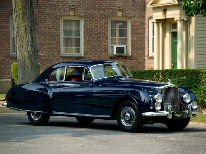 Dark Blue Bentley parked in front of a brick building