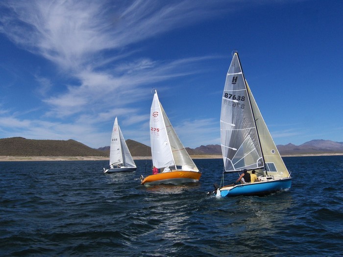 Sailboats racing on a lake under a blue sky