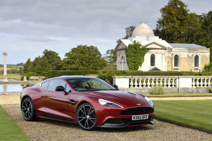 Red Aston Martin Vanquish parked in front of a building