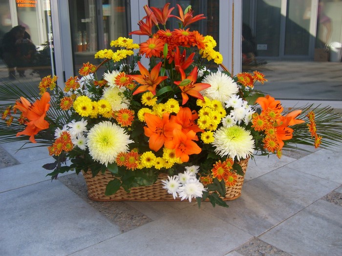 Orange and yellow flower bouquet in a wicker basket