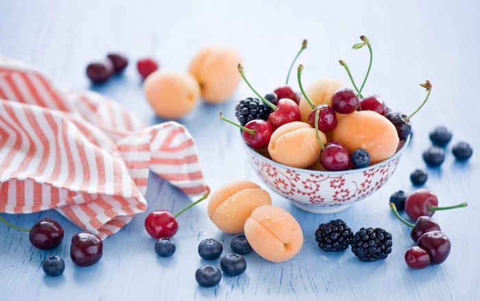 Bowl of fresh fruit with cherries, apricots, blueberries, and blackberries