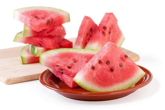 Slices of watermelon on a plate and cutting board