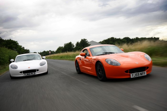 Two Ginetta G40R sports cars on a road