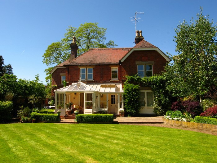 Brick house with conservatory and manicured lawn in Richmond, England
