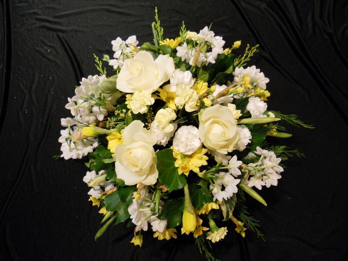 White and yellow floral arrangement on black fabric