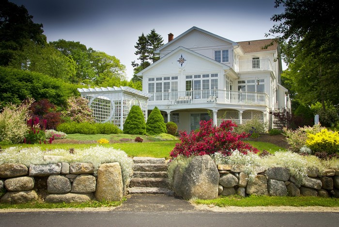 White house with stone wall and garden