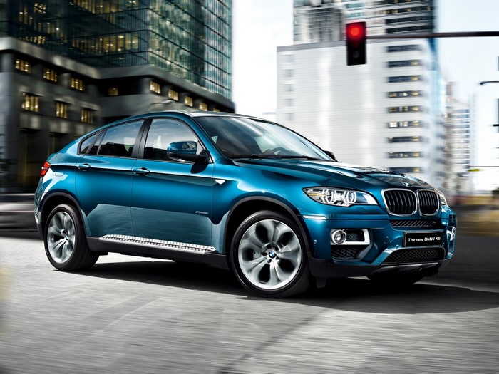 Blue BMW X6 driving in a city