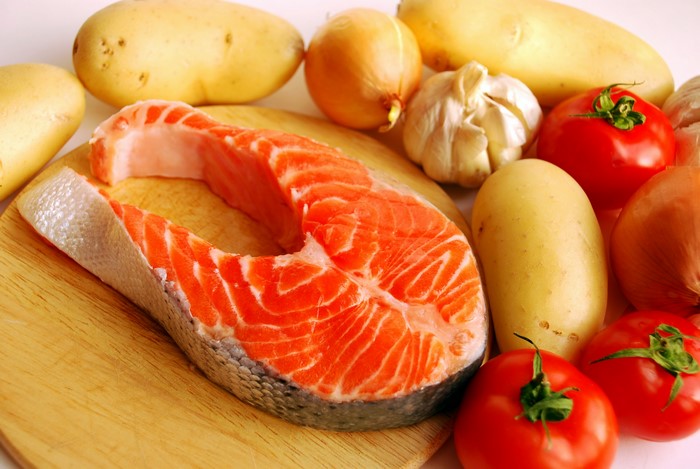 Salmon steak with potatoes, tomatoes, and onions
