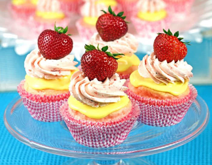 Strawberry cupcakes with pink frosting and yellow filling