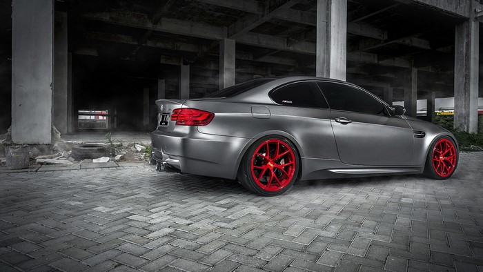 Matte gray BMW M3 with red wheels parked