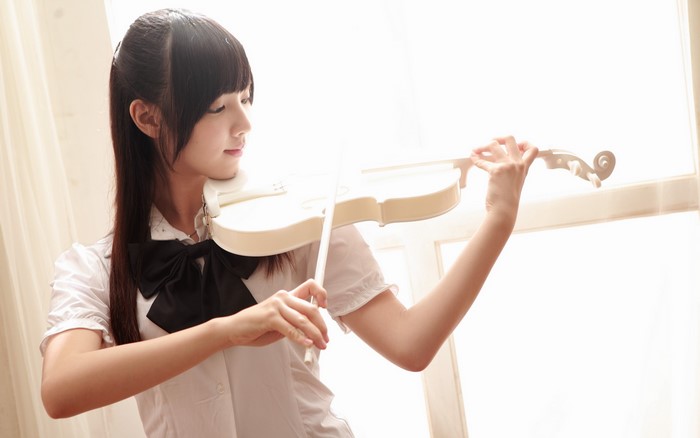 Asian girl playing a white violin