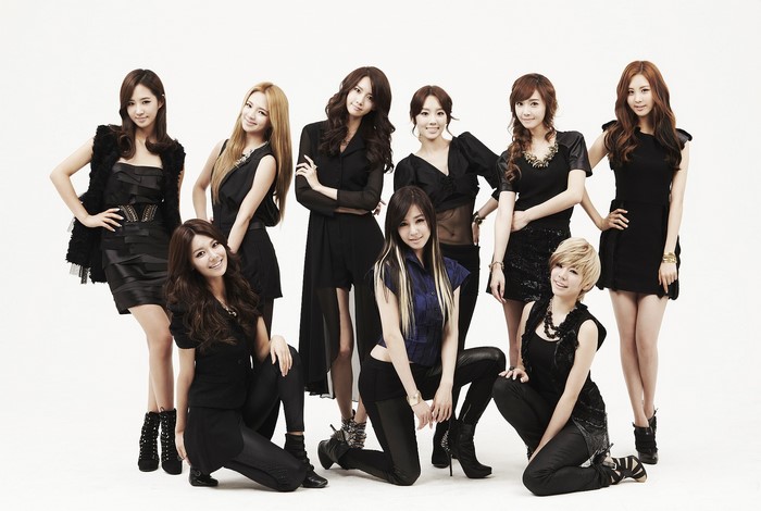 Nine Asian women in black outfits posing