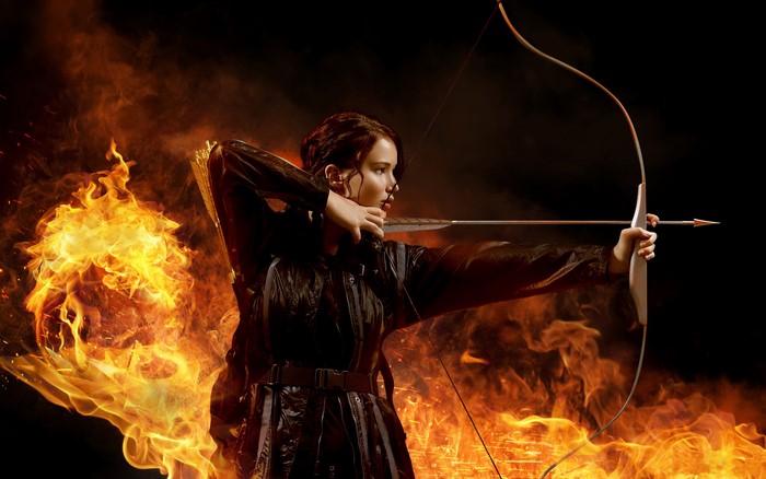 Katniss Everdeen from The Hunger Games with a bow and arrow amidst fire