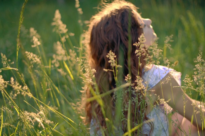 Brown haired girl in tall grass