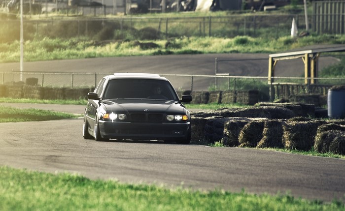 Black BMW 740i E38 on a race track