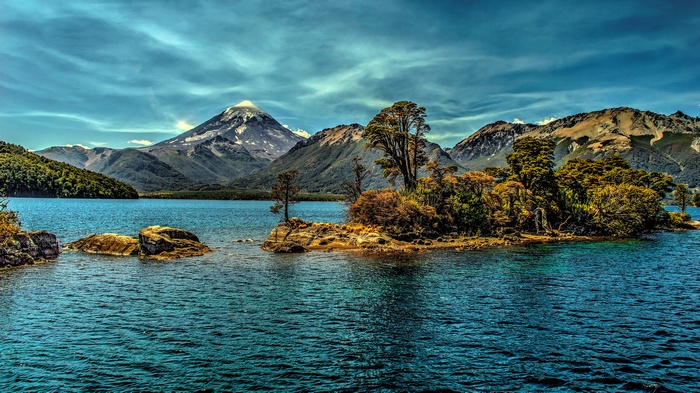 Island in a lake with mountains and a volcano
