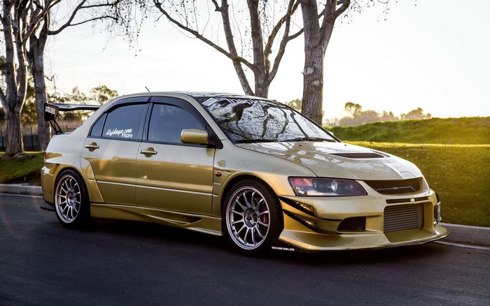 Gold Mitsubishi Lancer Evolution 9 with large rear spoiler