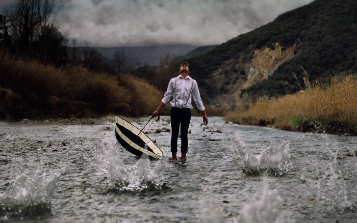 Man with umbrella in a river