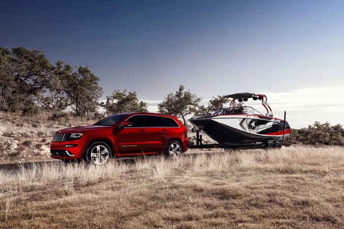 Red Jeep Grand Cherokee SRT towing a boat