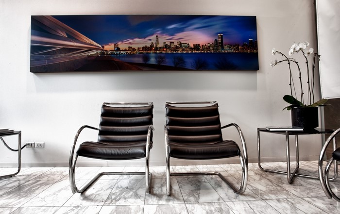 Modern waiting room with chairs and cityscape art