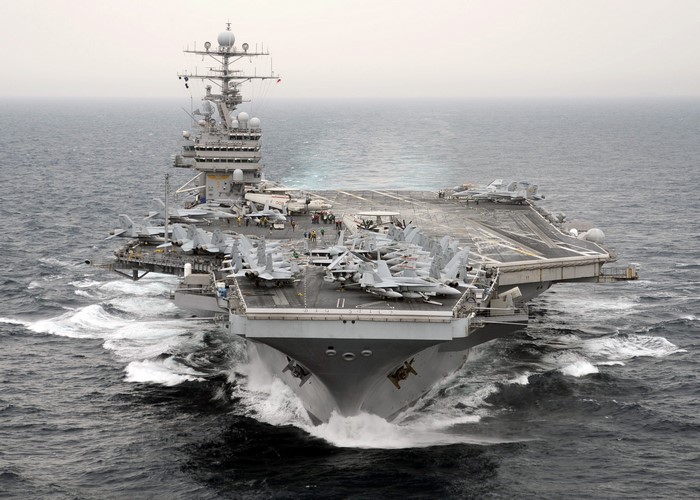 Aircraft carrier with fighter jets on deck at sea