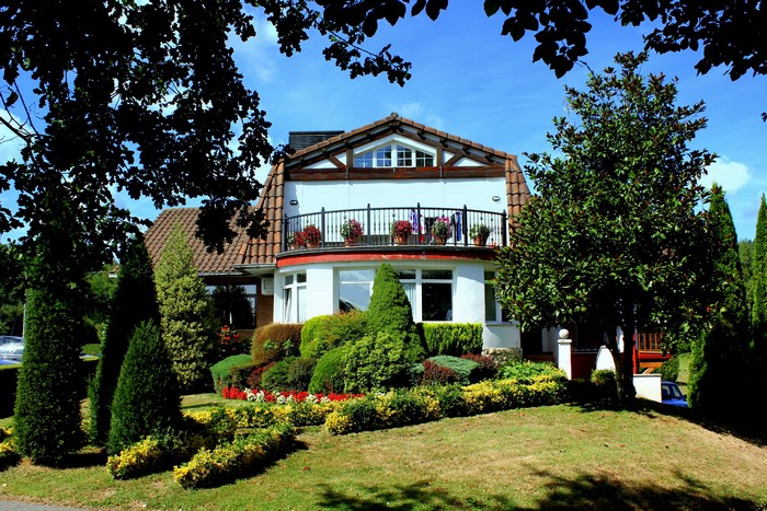 House with balcony and manicured garden