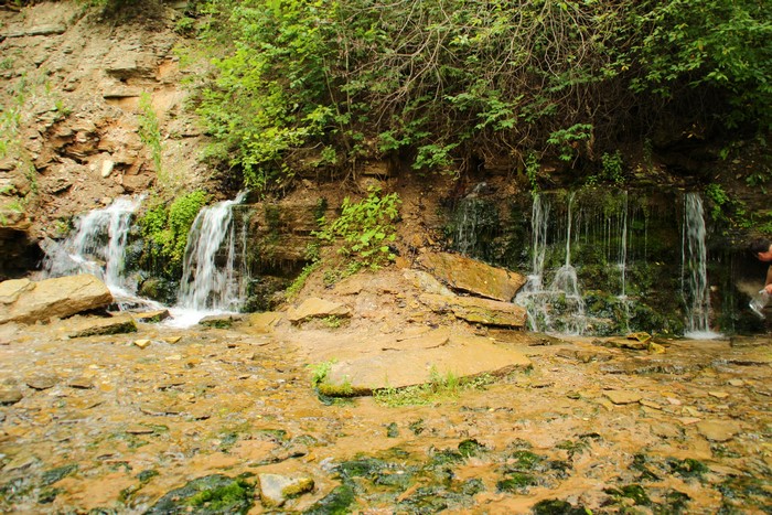 Small waterfalls cascading over mossy rocks in a forest