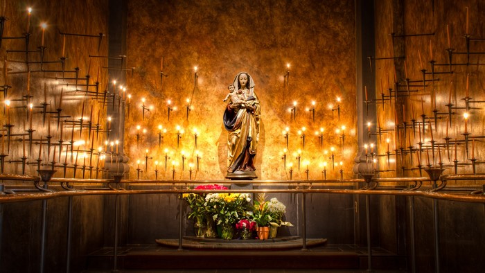 Statue of Mary and Jesus surrounded by candles