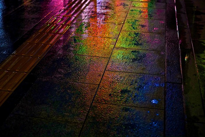 Wet pavement with colorful reflections in Hiroshima, Japan at night