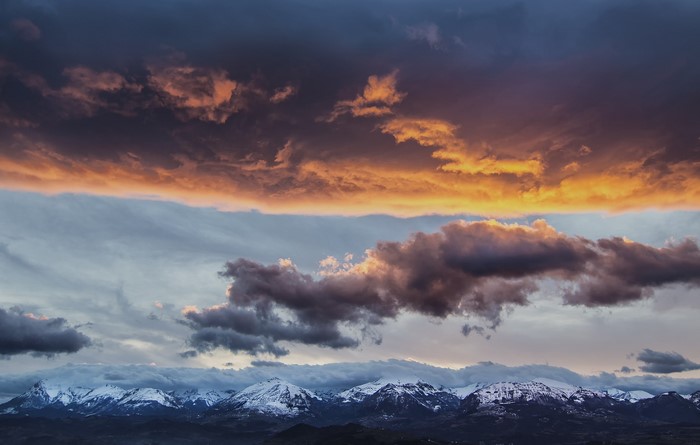 Dramatic sunset clouds over snow-capped Apennine Mountains in Italy