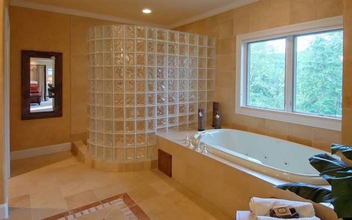 Bathroom with bathtub and glass block wall