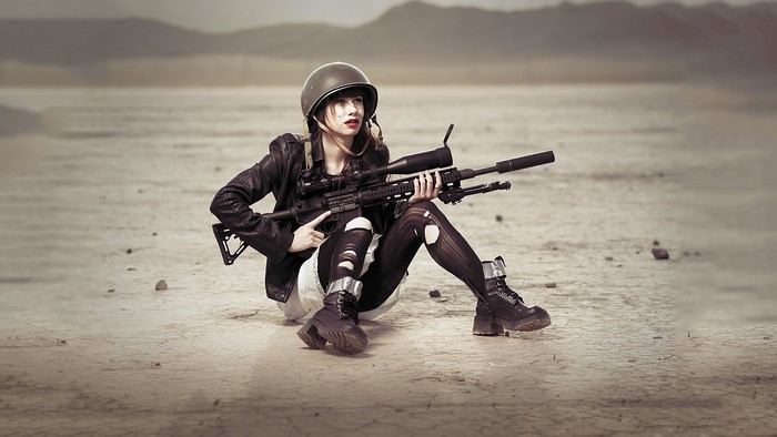 Woman with sniper rifle in desert